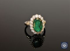 An 18ct white gold emerald and diamond ring, the oval-cut Zambian emerald weighing 5.