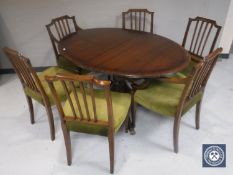 A Regency style inlaid mahogany oval extending dining table together with a set of six chairs