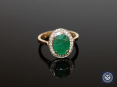 An 18ct gold and platinum emerald and diamond ring, the oval-cut emerald weighing 2.