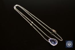 An 18ct white gold tanzanite and diamond necklace, the pear-cut violet-blue tanzanite weighing 8.