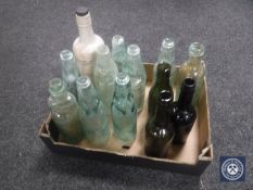A box containing twelve vintage glass bottles together with a stoneware bottle