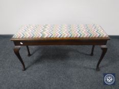 An early 20th century mahogany upholstered duet piano stool