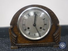 A 20th century oak cased mantel clock with silvered dial