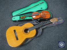 A cased Stentor student violin and bow together with a Spanish acoustic guitar