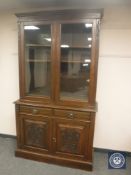 An Edwardian mahogany glazed bookcase fitted with two drawers,