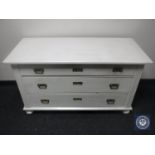 A continental oak painted three drawer chest on bun feet