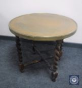 A circular brass topped table on barley twist legs