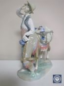 A Lladro figure of a man with a donkey CONDITION REPORT: Chip to man's hat which has