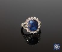 An 18ct white gold sapphire and diamond cluster ring, the oval-cut Kashmir sapphire weighing 4.