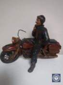 A wooden figure of a motorcyclist on a vintage bike