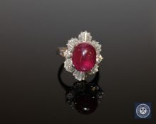 A 14ct white gold and ruby diamond ring, the oval, cabochon, medium-red ruby weighing 6.