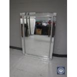An all glass framed bevelled mirror