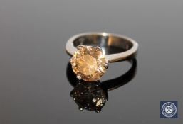 An 18ct white gold solitaire diamond ring, the brilliant-cut, cognac coloured diamond weighing 3.