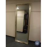 A tall traditional style mirror in a silvered framed,