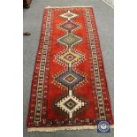 A Caucasian design rug on red ground,