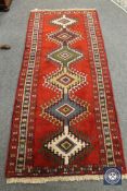 A Caucasian design rug on red ground,