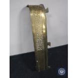 An antique brass fire curb