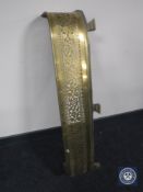 An antique brass fire curb