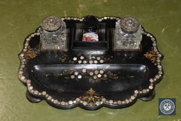 A Victorian mother of pearl inlaid papier mache desk stand with ink wells by Jennings & Betteridge