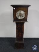 An oak granddaughter clock with silvered dial,