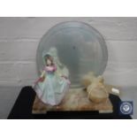 An Art Deco marble mirrored back table stand with lidded trinket pot and a figure of a lady