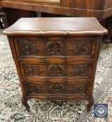 A continental carved beech serpentine front small chest of three drawers,