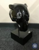A resin bust of a panther on plinth