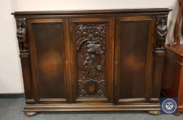 A continental carved beech triple door sideboard,