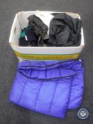 A crate of miscellaneous new clothing, some still with tags, coats, jeans, sleeping bag, etc.