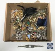 A box of assorted costume brooches and a lady's silver wrist watch