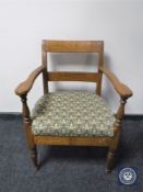 An antique oak armchair in tapestry fabric