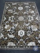 A contemporary floral rug on brown ground 170cm by 120cm