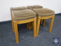 Four upholstered bar stools on painted bases