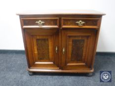 An inlaid walnut double door cabinet on bun feet