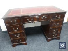 A reproduction mahogany twin pedestal writing desk with tooled leather top