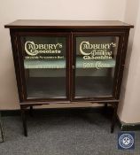 An Edwardian and later inlaid mahogany display cabinet with "Cadbury's" advertising,
