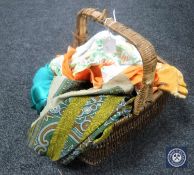 A wicker hand basket containing scarves