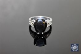 An 18ct white gold solitaire diamond ring, the pear-cut, colour-enhanced black diamond weighing 6.