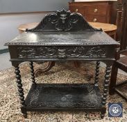 A Victorian carved oak and ebonised hall table fitted a drawer,