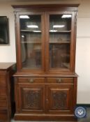 An Edwardian mahogany glazed bookcase fitted with two drawers,