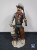 A contemporary figure of a cowboy with a shotgun