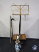 An early 20th century music stand on metal base, pottery table lamp, walking stick,