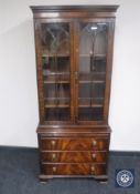 A mahogany Regency style bookcase fitted three drawers beneath and slide with lion mask handles