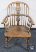 An antique elm kitchen armchair