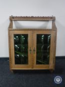 A blonde oak wall cabinet with leaded glass doors