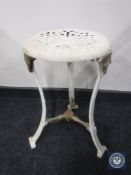 An antique painted cast metal stool on tripod base