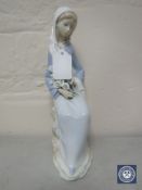 A Lladro figure of a lady seated with flowers