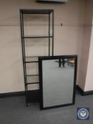 A metal glass Ikea Vittsjo five tier shelving unit and a black framed mirror