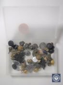 A box containing military and service buttons and badges, miner's lamp token,