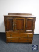 An Edwardian oak triple door linen chest fitted two drawers beneath